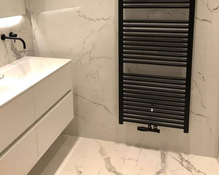Hoogglans marmerlook tegels met zwart sanitair in de badkamer
