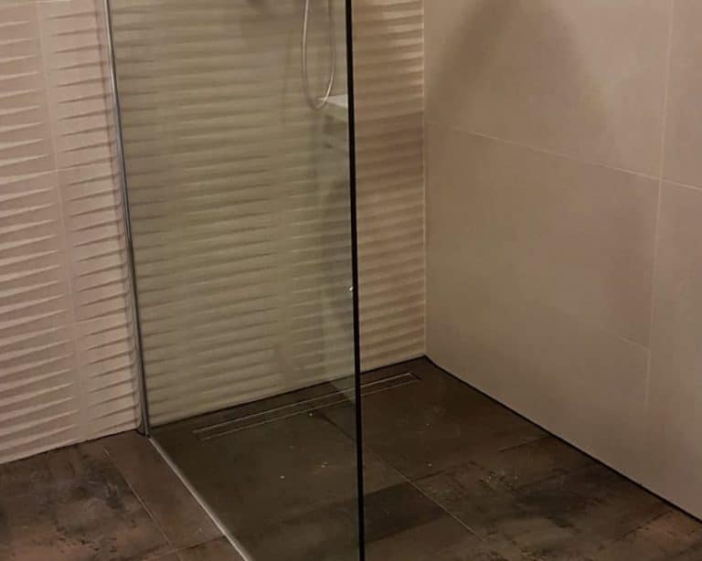 Metallook vloertegels in combinatie met groot formaat wandtegels en golvende decortegels