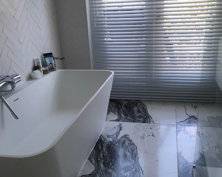 Badkamer met marmerlook tegels en visgraat handvorm tegels
