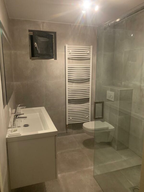 Badkamer met betonlook tegels op de vloer en wand