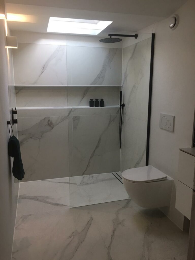Badkamer met marmerlook tegels, hexagon tegels en gestucte wanden