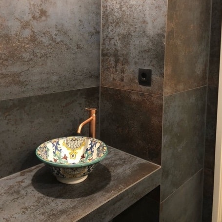 Industriële badkamer met metallook en Portugese tegels uit Amsterdam
