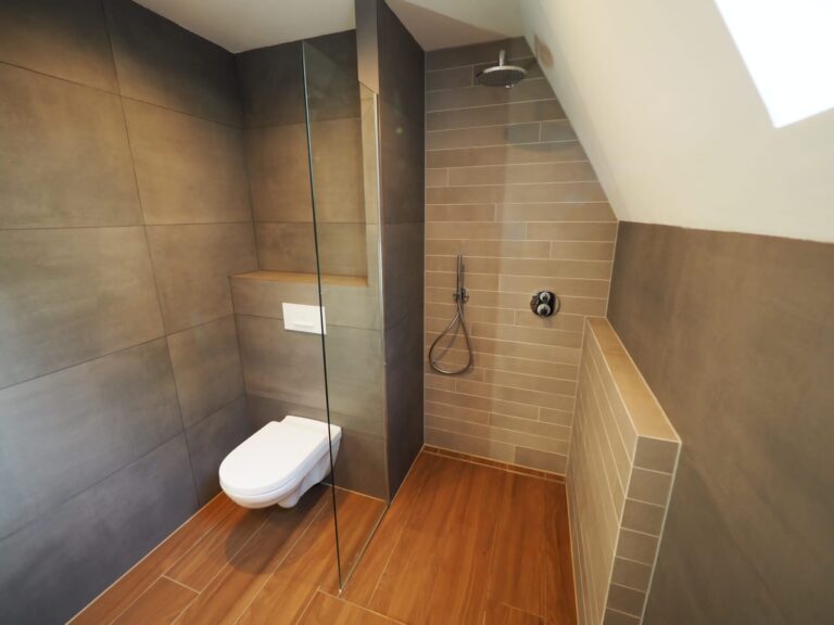 WC en badkamer met betonlook tegels, tegelstroken en keramisch parket