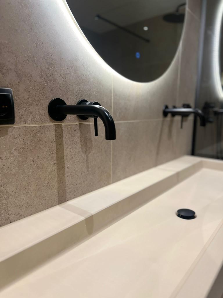 Zwarte kraan beige tegels