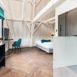 Plak-pvc donkerbruin eiken visgraat in een hotelkamer, uitgevoerd project van Tegels en Laminaat