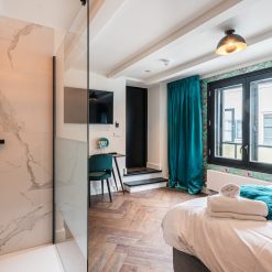 Plak-pvc donkerbruin eiken visgraat in een hotelkamer, uitgevoerd project van Tegels en Laminaat