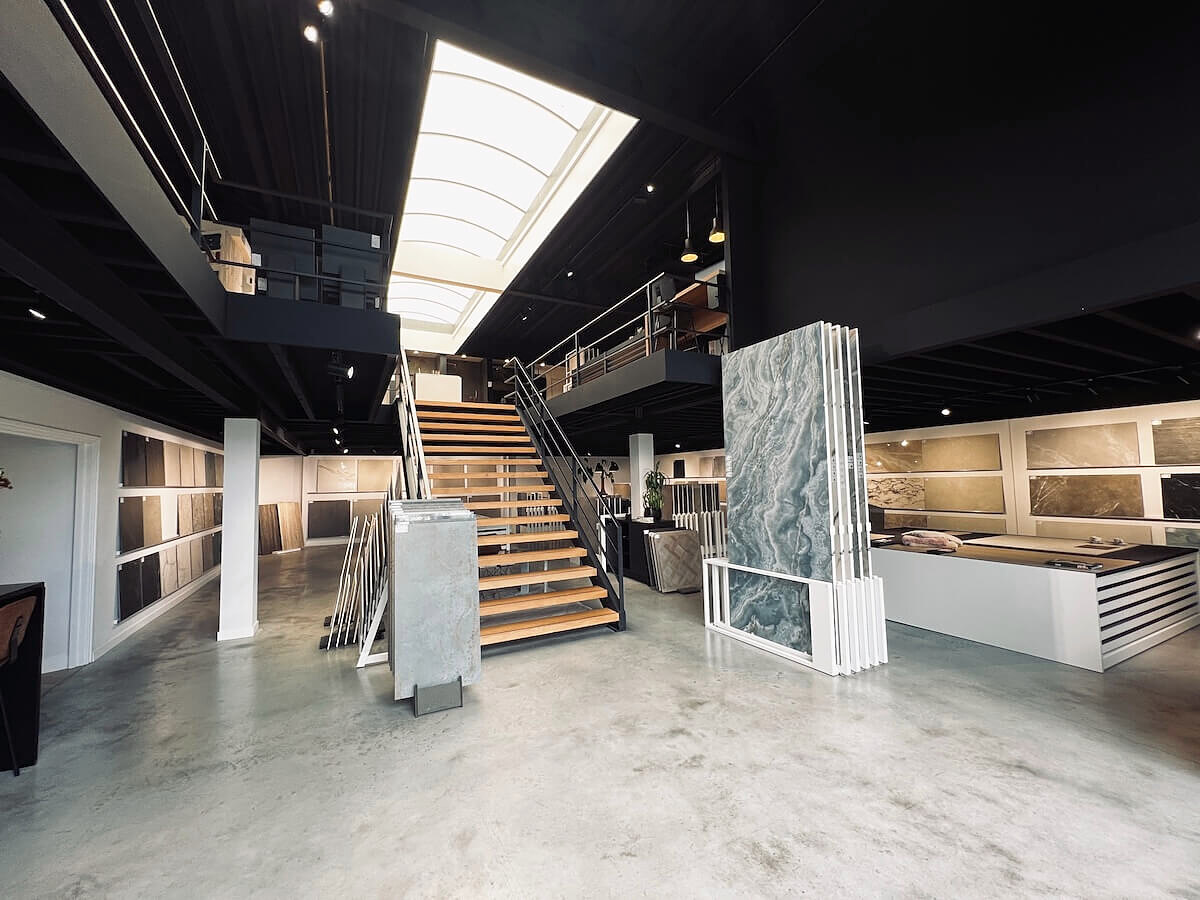 Showroom van Tegels en Laminaat in Hoofddorp, met tegelopstellingen en de trap naar de verdieping