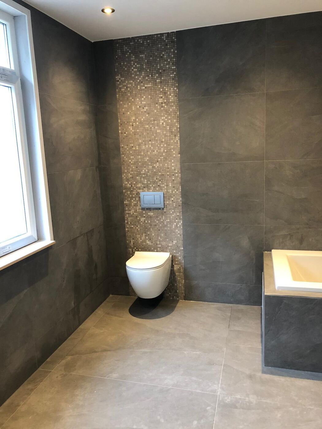 Mozaïek als strook achter het toilet