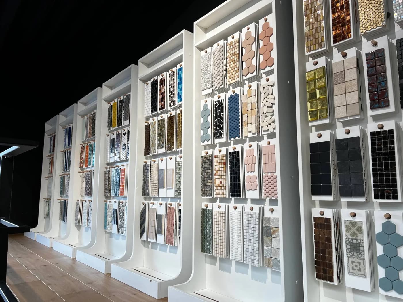 De mozaïekwand in de showroom, met stalen in allerlei kleuren en vormen