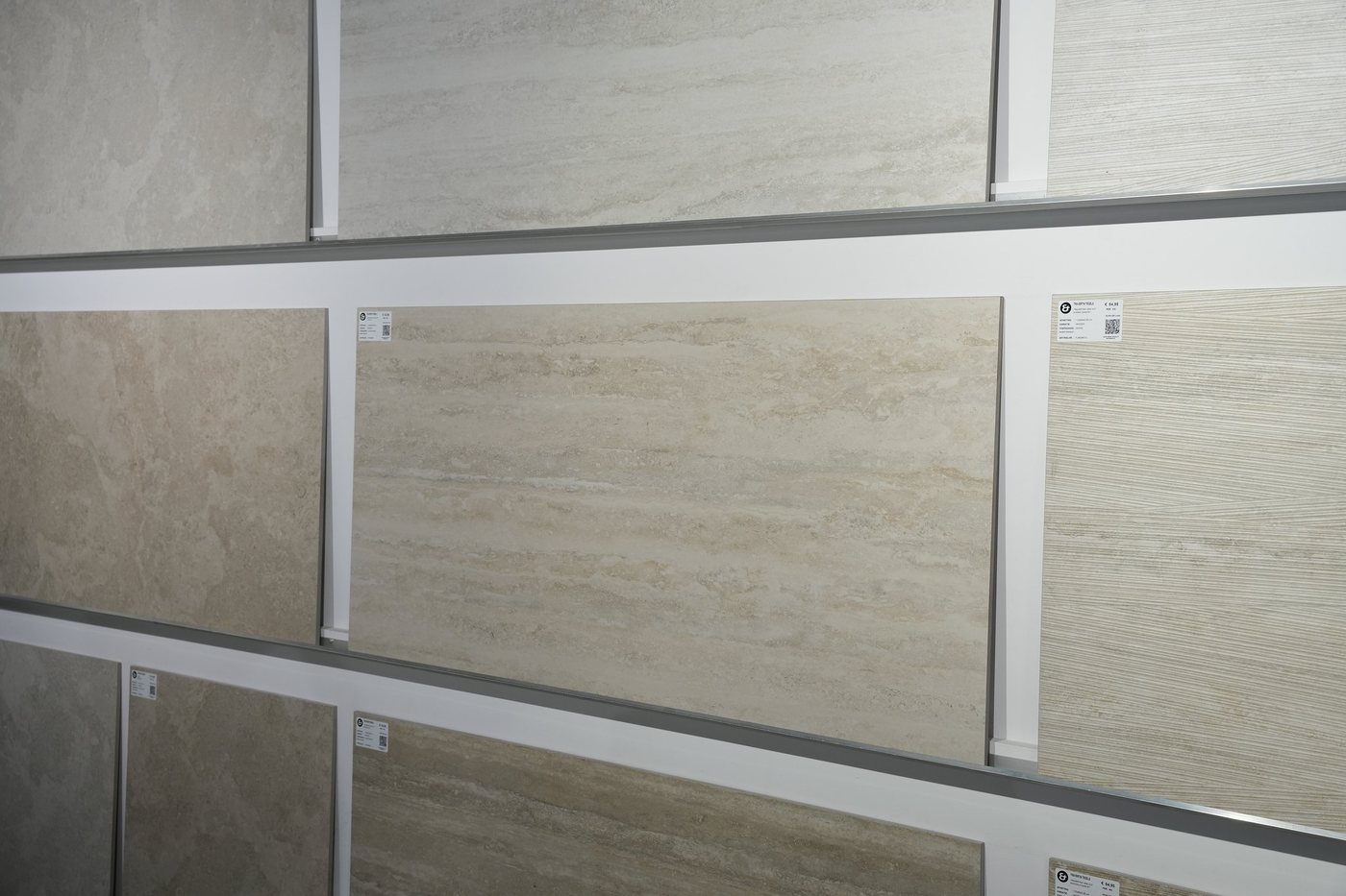 Travertin tegels in verschillende tinten aan de tegelwand in de showroom