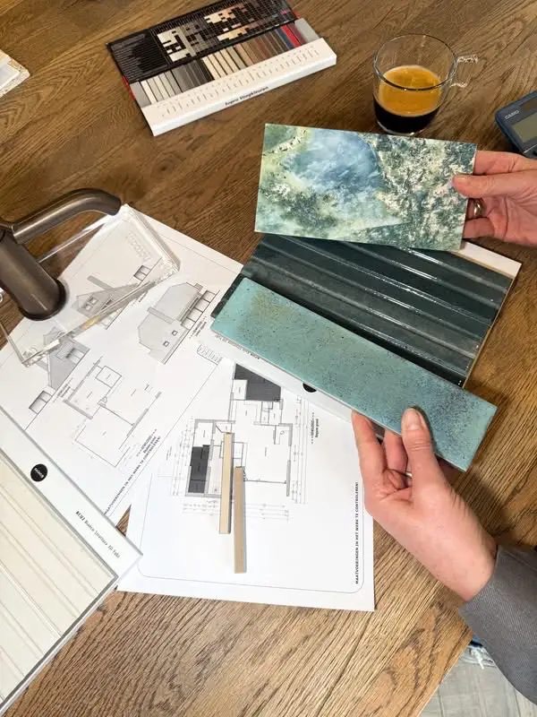Tegelstalen naast de bouwtekening van een badkamer aan de adviestafel